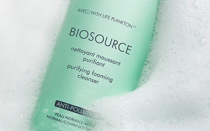 Biotherm Biosource purifying foaming cleanser bottle with Life Plankton, surrounded by soft foam bubbles.