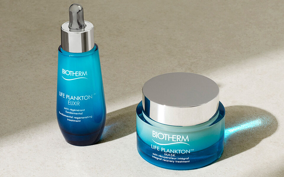 Biotherm Life Plankton Elixir serum and Life Plankton Mask placed side by side on a sunlit stone surface.