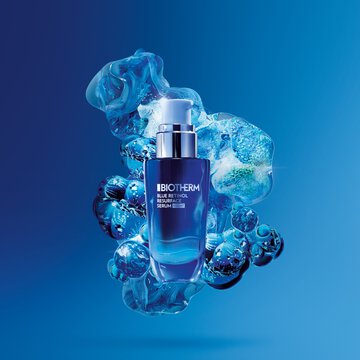Biotherm Blue Therapy Multi-Correct Serum bottle surrounded by abstract blue bubbles on a gradient blue background.